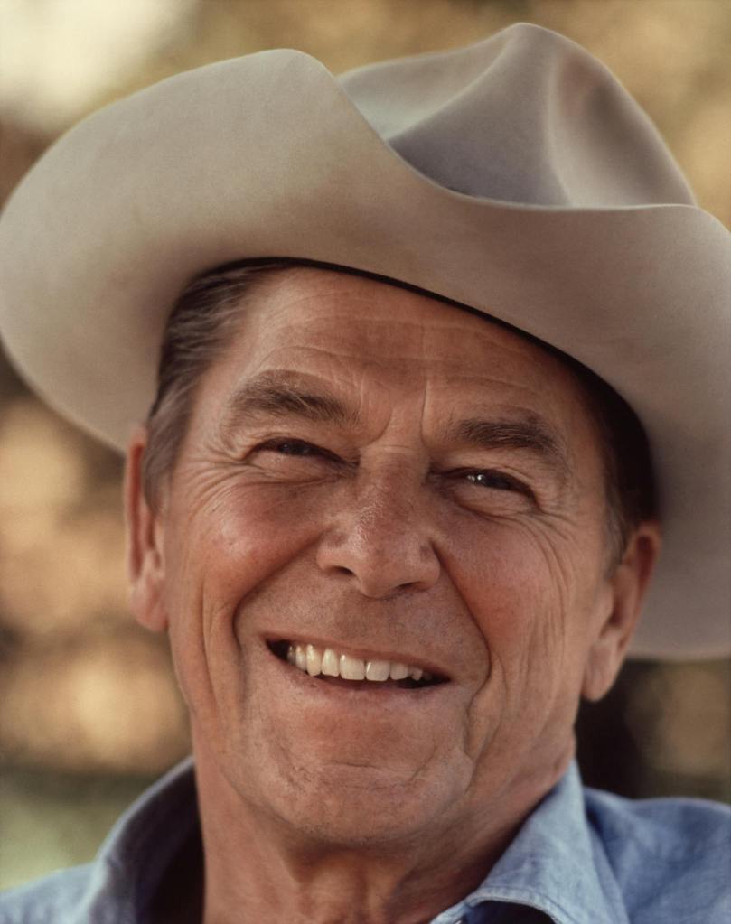 a photograph of a smiling cowboy looking into the camera